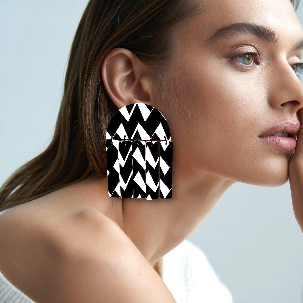 Brincos statement pretos e brancos de festa numa mulher elegante