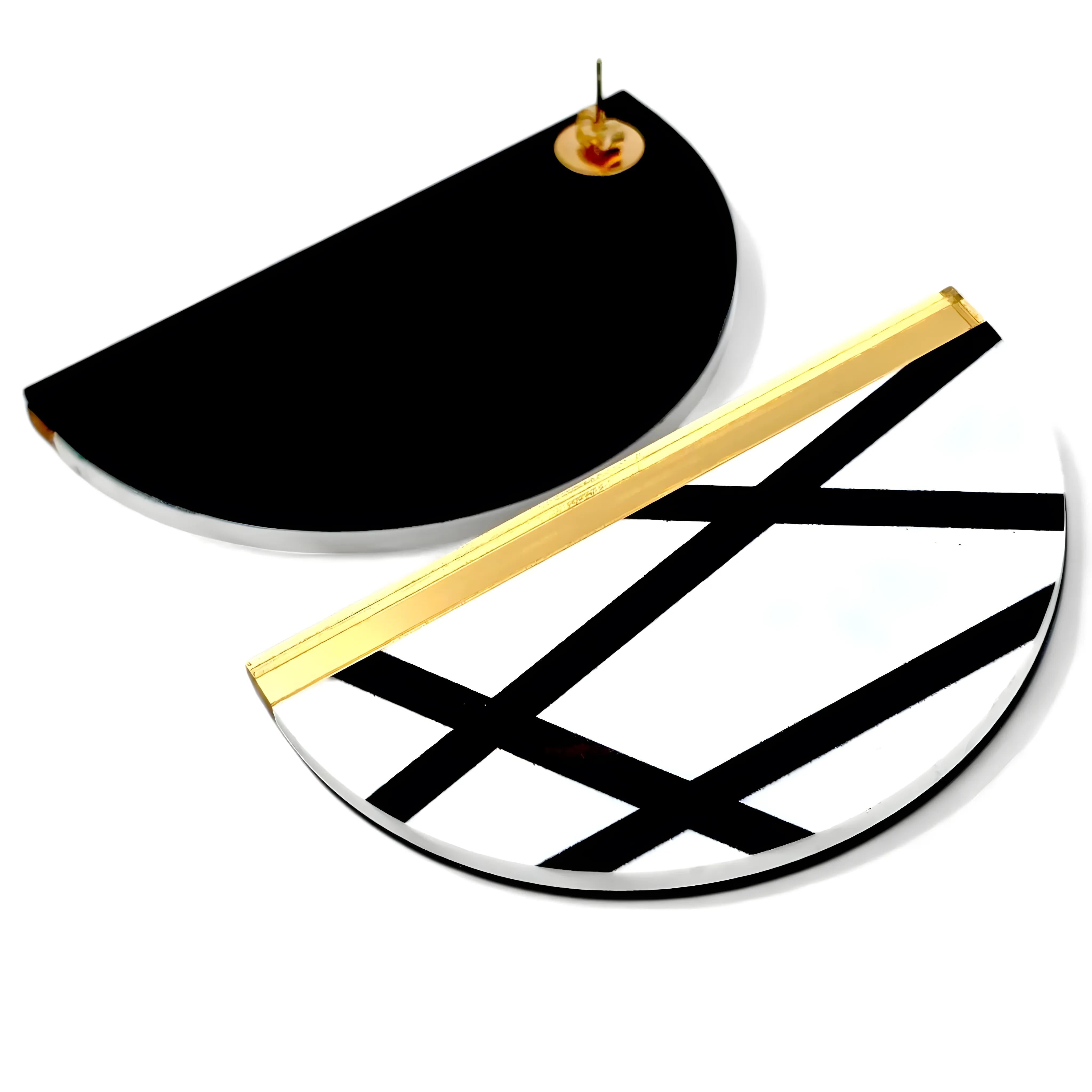 Brincos redondos com linhas pretas e detalhe dourado vistos de costas, mostrando o fecho