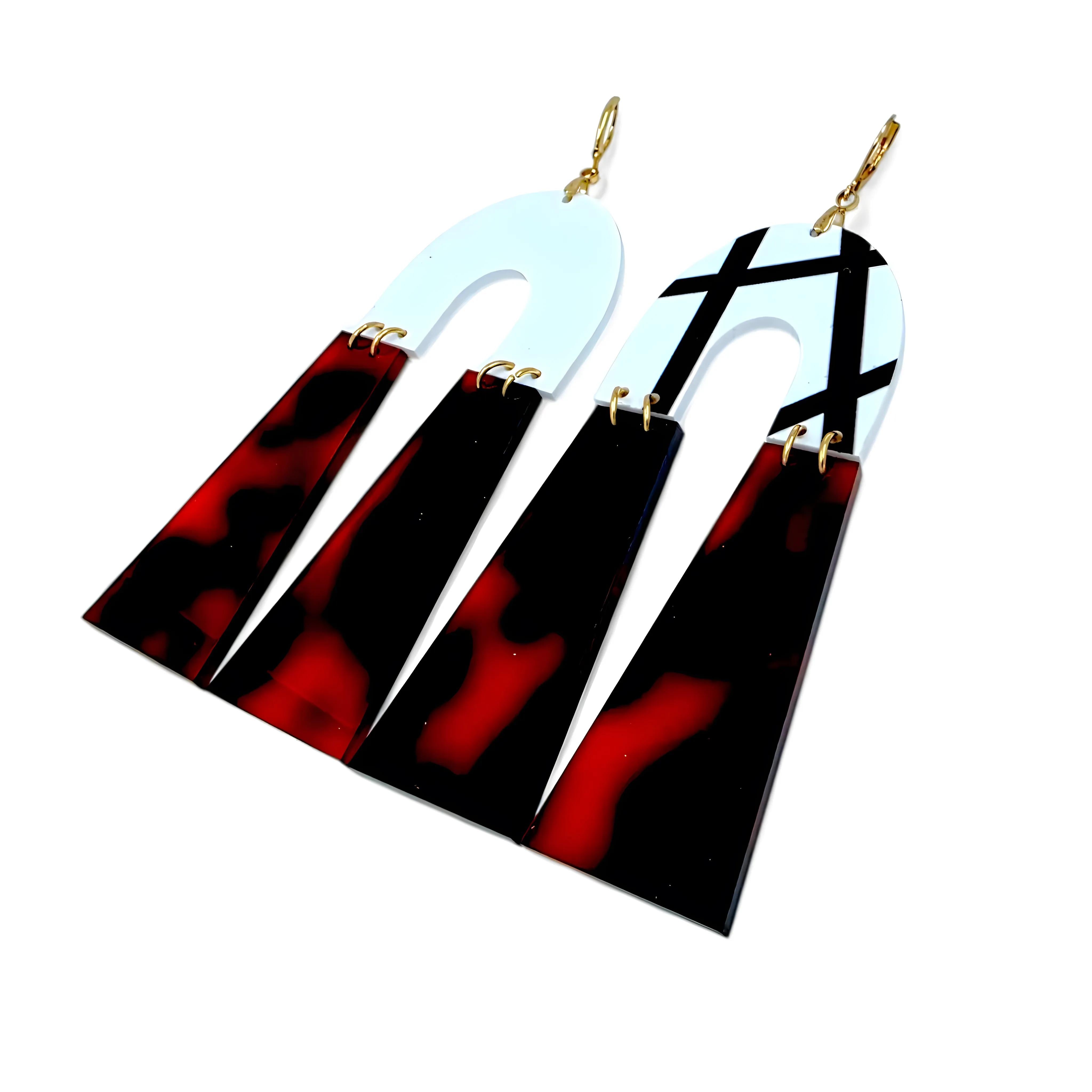 Brincos geométricos com base branca e detalhe tartaruga vistos de costas, mostrando o fecho dourado