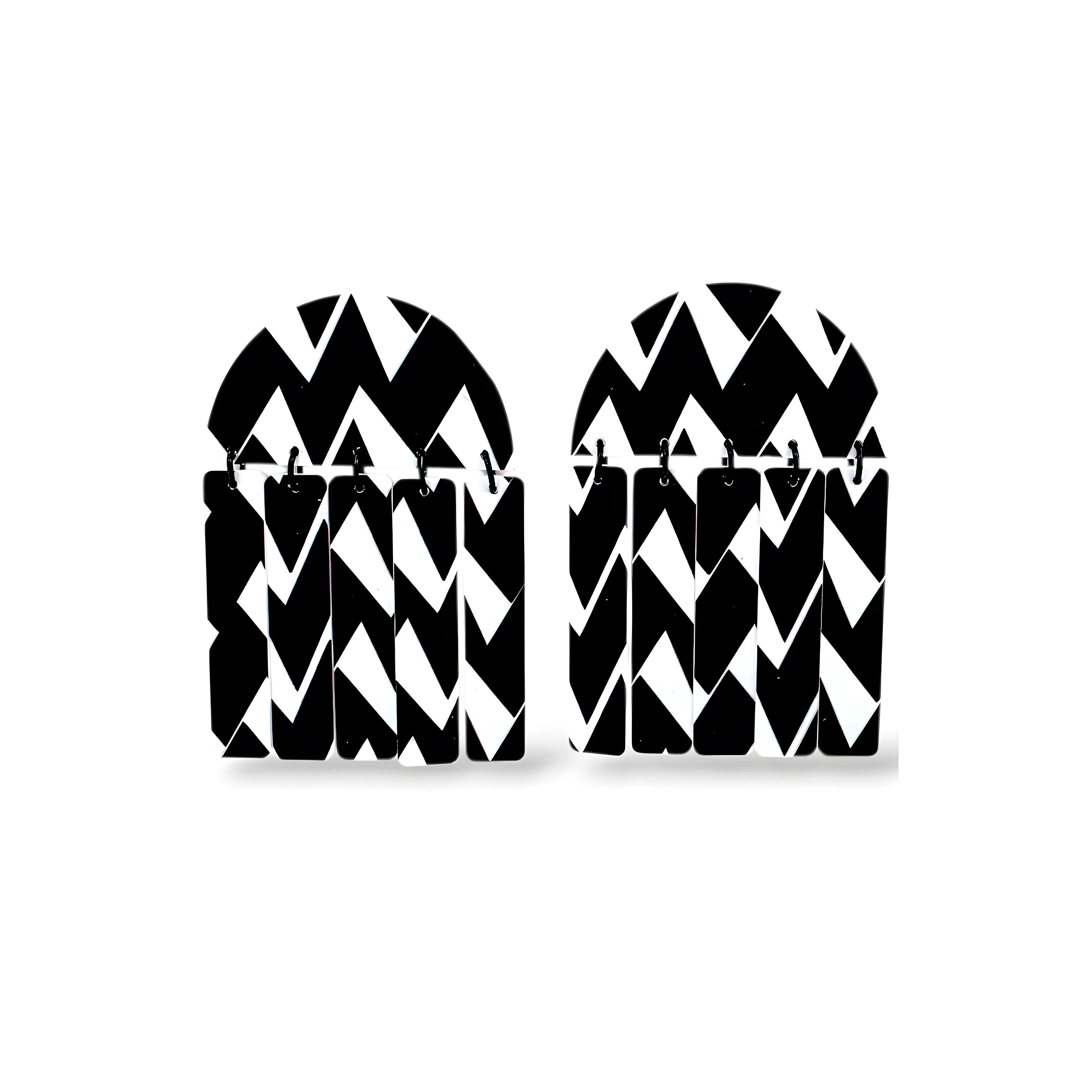 Par de brincos geométricos em preto e branco com padrão zigue-zague e formato arqueado
