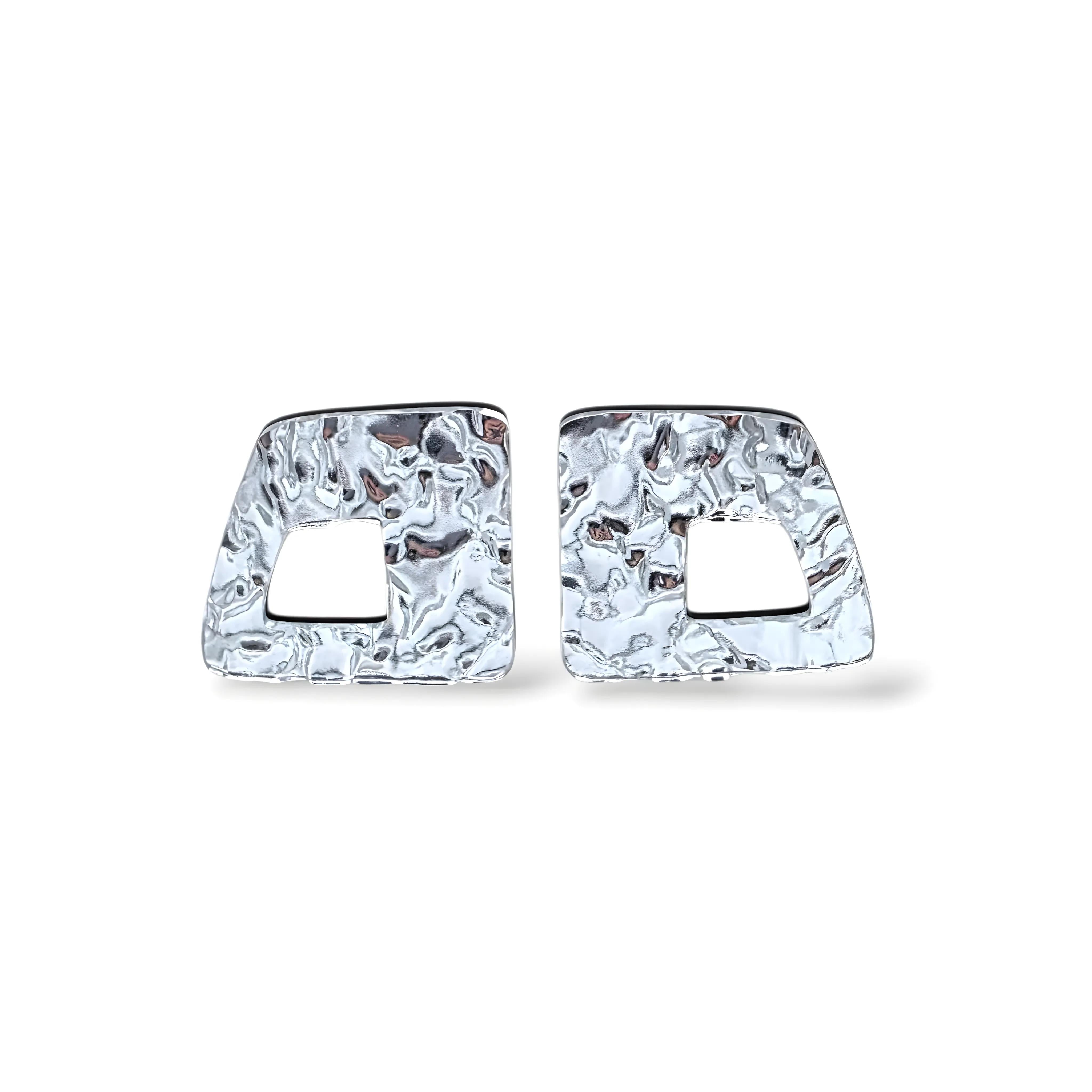 Par de brincos prateados com textura martelada e recorte geométrico central
