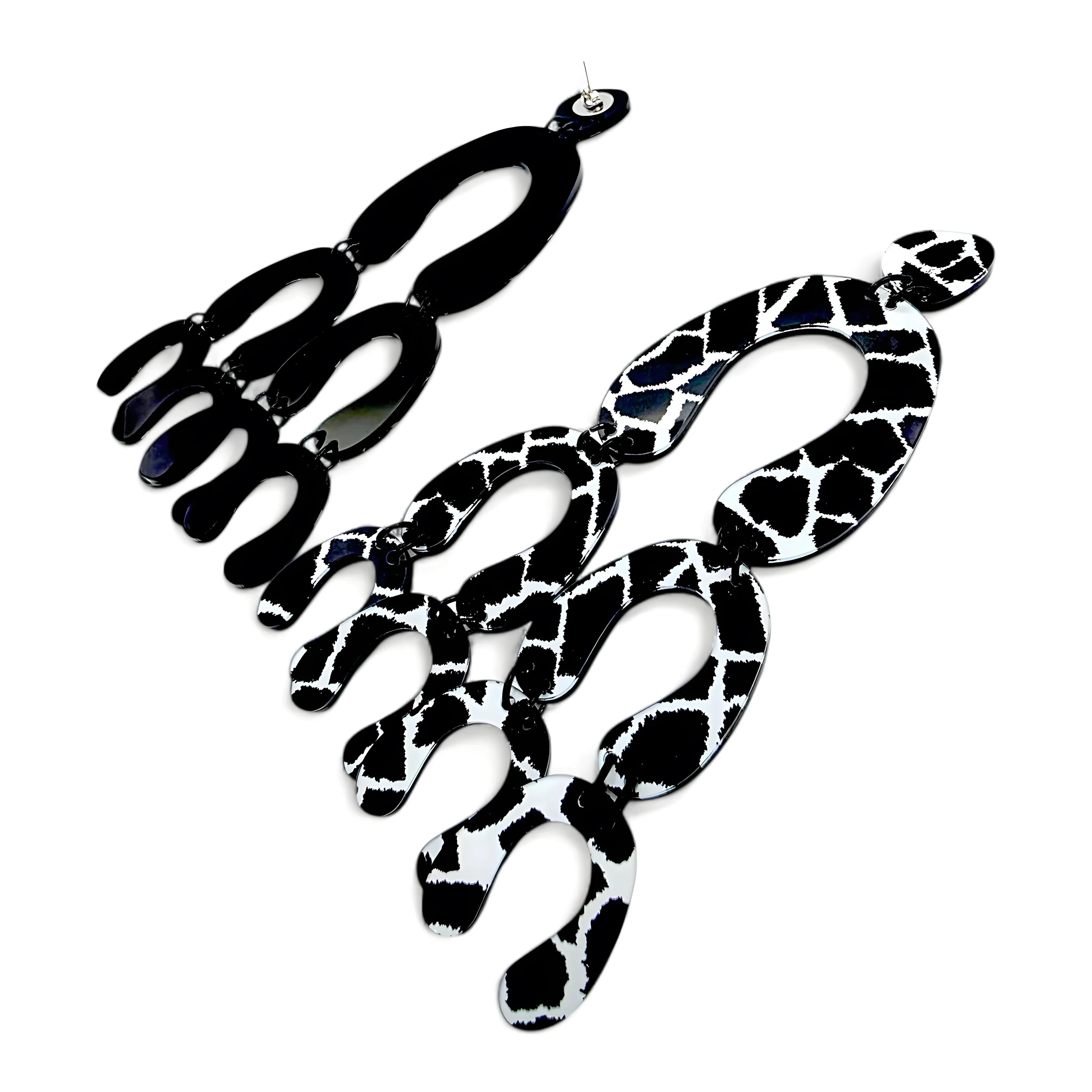 Brincos longos articulados com estampa preto e branco tipo girafa vistos de costas, mostrando o fecho